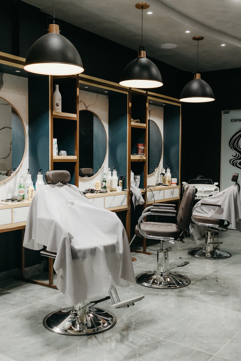 a hair salon with chairs and mirrors and lights